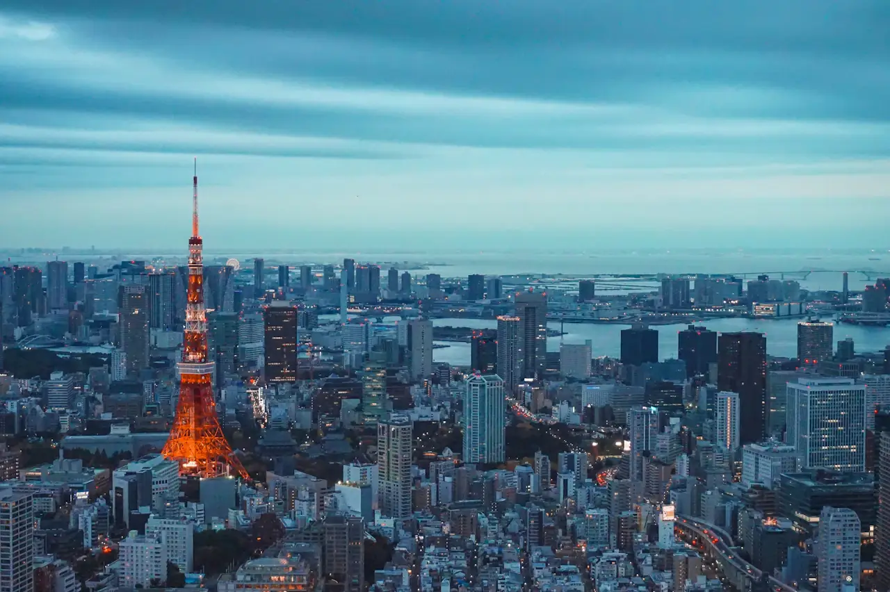 Tokyo Tower lit at dusk above the city skyline, shot from the Mori Tower deck in Roppongi