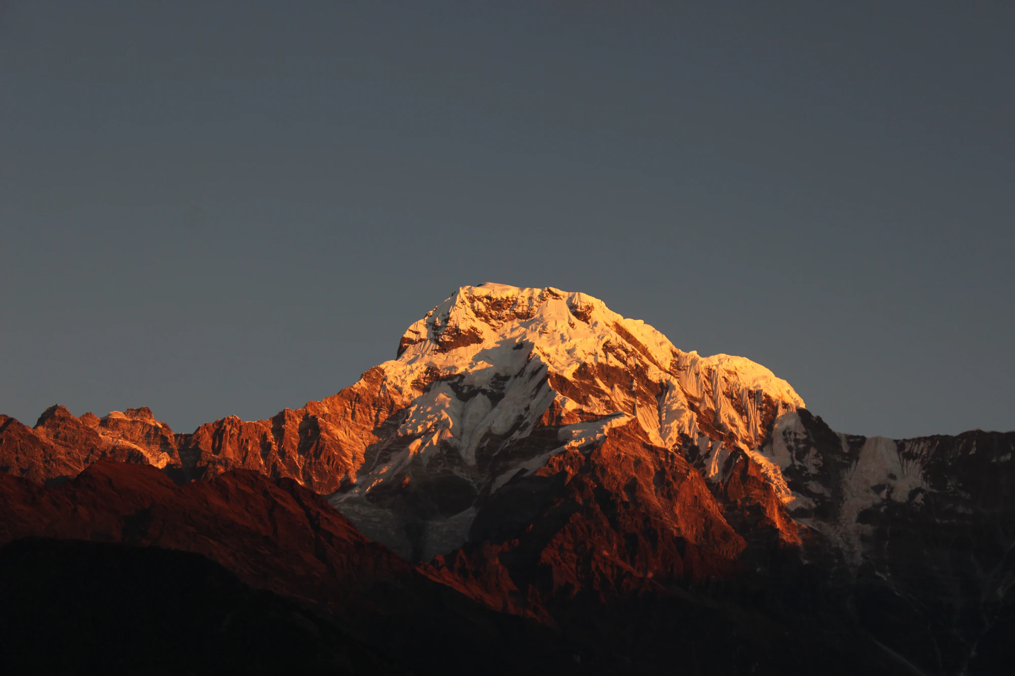尼泊尔甘德鲁克远望的雪山，夕照把山脊染成橙红