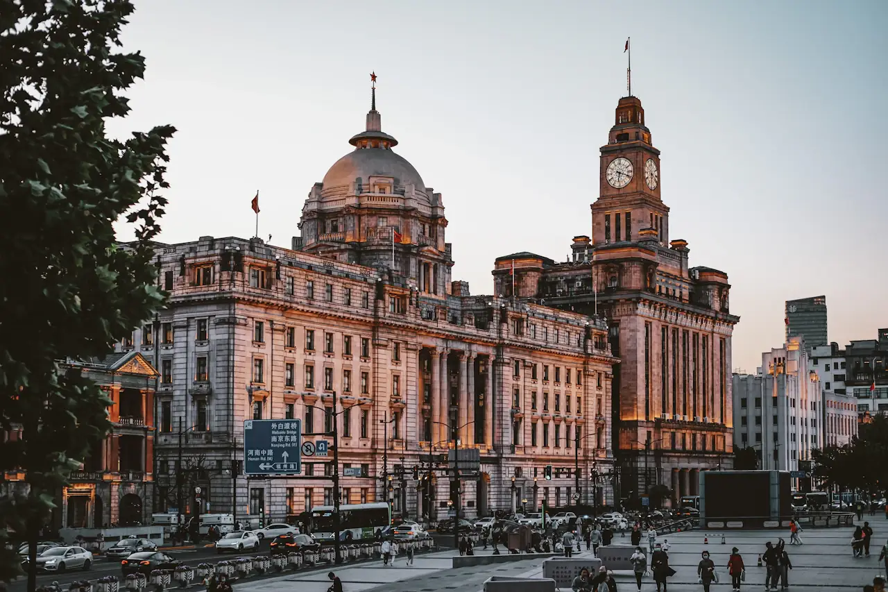Historic domed and clock-towered buildings on the Bund, Shanghai, in warm evening light