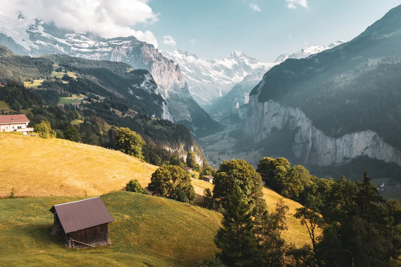 A timber barn on the meadows of the Lauterbrunnen Valley with the Jungfrau massif behind