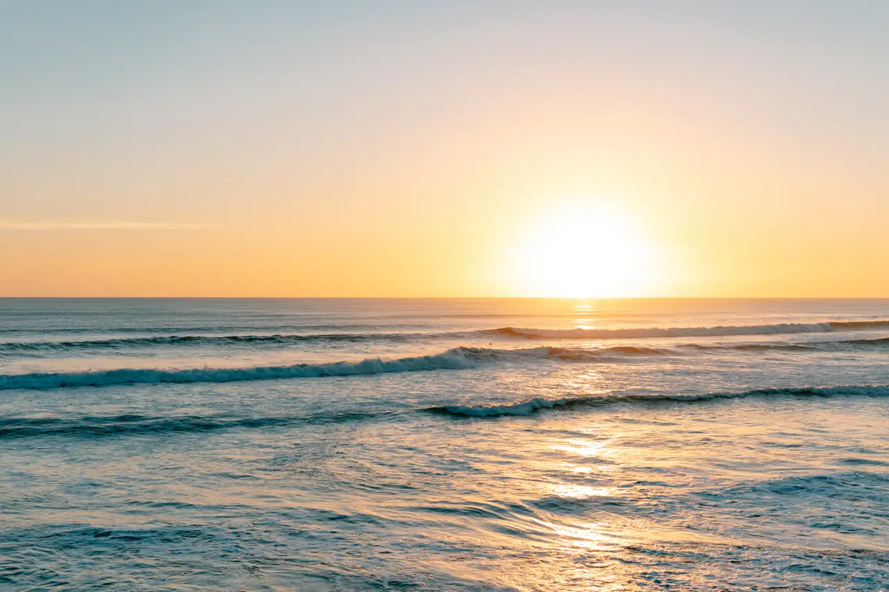 Open sea at sunrise, lines of swell running to the horizon
