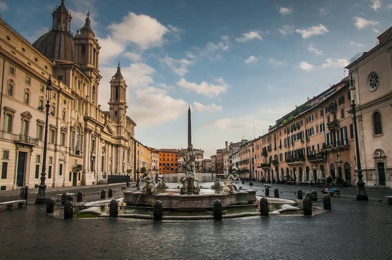 Piazza Navona in Rome: the central fountain and obelisk, ochre palazzi on both sides and clouds above